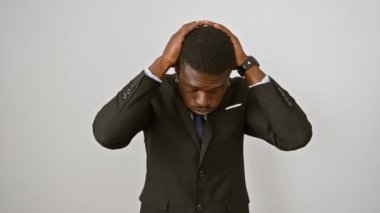 Afro-Amerikalı bir adam, stres ve acı içinde, acı çeken, yüzü ağrıyan biri, beyaz arka planda tek başına duruyor. Baş ağrısı, migren üzüntü ve depresyona neden olur. İş elbisesi, el ele..