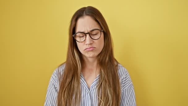 青い目と眼鏡で苦しむ若い女性 孤立した黄色の背景に悲しみと怒りを表現し 不安と心配の肖像画 — ストック動画