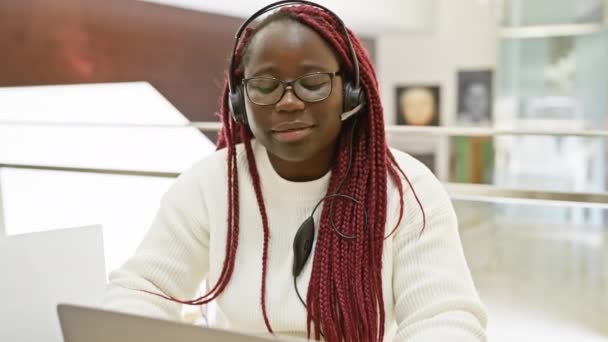 Mulher Africana Focada Com Tranças Usando Fone Ouvido Trabalhando Laptop — Vídeo de Stock
