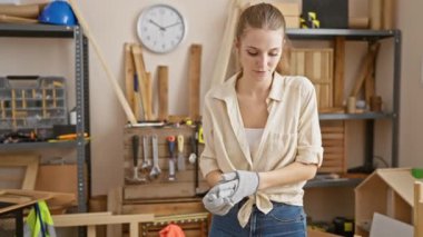 Atölyedeki genç kadın marangozluk aletleri ile marangozluk yapıyor, yetenekli ve profesyonel bir aura yayıyor.
