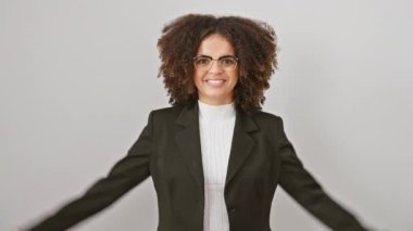 Kendine güvenen, kıvırcık saçlı, kaslı kollarını gösteren, fitness gücü gösteren İspanyol bir kadın. Beyaz arka planda, sağlık ve yaşam tarzı başarısının bir temsili olarak izole edilmiş duruyor..
