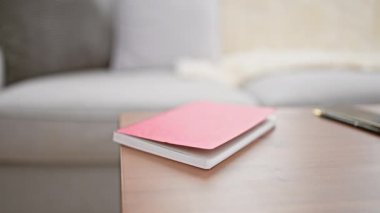 Oturma odasında kitap okuyan, beyaz elbiseli, olgun bir kadın.