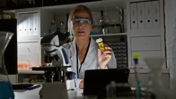 Medelålders Blond Kvinna Undersöker Medicinering Laboratoriemiljö Representerande Professionell Sjukvårdsmiljö — Stockvideo