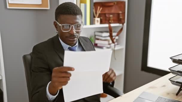 Профессиональный Черный Мужчина Внимательно Читает Документы Современных Офисных Условиях — стоковое видео