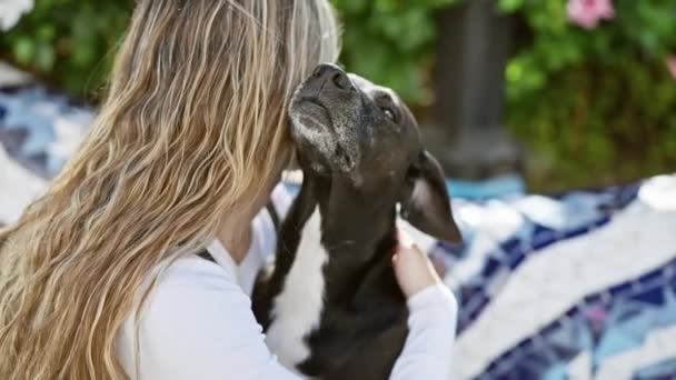 Ξανθιά Γυναίκα Κατοικίδια Ζώα Φροντίδα Μαύρο Σκυλί Στον Ηλιόλουστο Κήπο — Αρχείο Βίντεο
