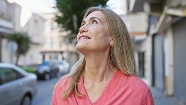 Dojrzała Kobieta Uśmiechnięta Świeżym Powietrzu Środowisku Miejskim Odzwierciedlająca Pozytywne Nastawienie — Wideo stockowe