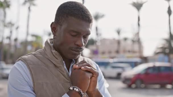 Contemplative African Man Praying City Street Palms Cars Blurry Background — Stock Video