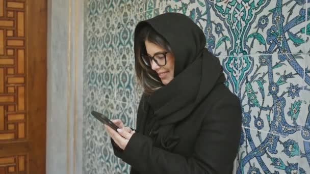 Uśmiechnięta Kobieta Hidżabie Pomocą Smartfona Tradycyjnymi Tureckimi Płytkami Tle Istanbul — Wideo stockowe