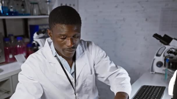 Modern Laboratuvarda Bilgisayar Kullanarak Laboratuvar Önlüklü Odaklanmış Afrikalı Erkek Bilim — Stok video