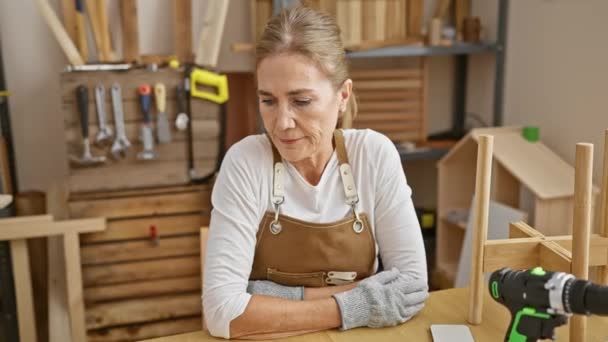 彼女の木工スタジオで保護手袋を身に着けている交差した腕を持つ成熟した女性 — ストック動画