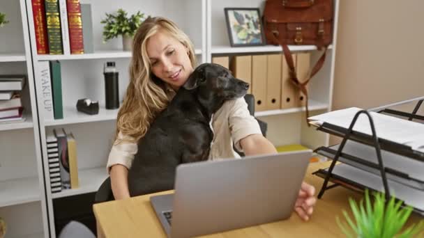 一个金发碧眼的年轻女人在一个现代化的办公室里依偎着她的黑色拉布拉多犬 享受着休息 — 图库视频影像
