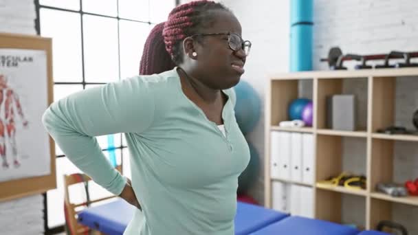 Афро Американка Косичками Испытывает Боли Спине Кабинете Физиотерапевтической Клиники — стоковое видео