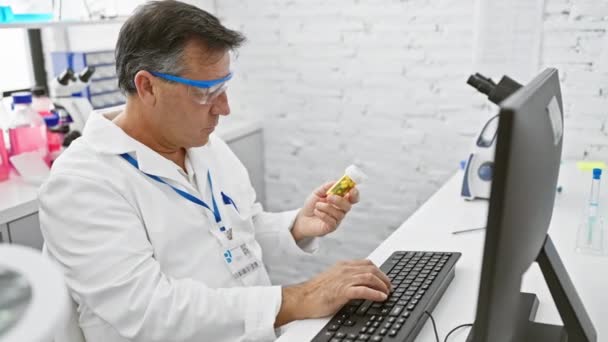 실험실에서 컴퓨터를 사용하는 약물을 분석하는 성숙한 과학자 — 비디오