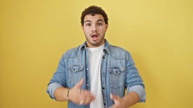 Şaşırmış Arap adam, sarı izole edilmiş arka plana karşı bir hata yüzünden ağzını pişmanlıkla kapatıyor.