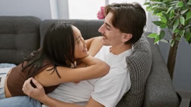 Irklar arası bir çift, bir erkek ve bir kadın, sıcak bir oturma odasında sevgiyle kucaklaşıyorlar, mutluluk ve şefkat iletiyorlar..