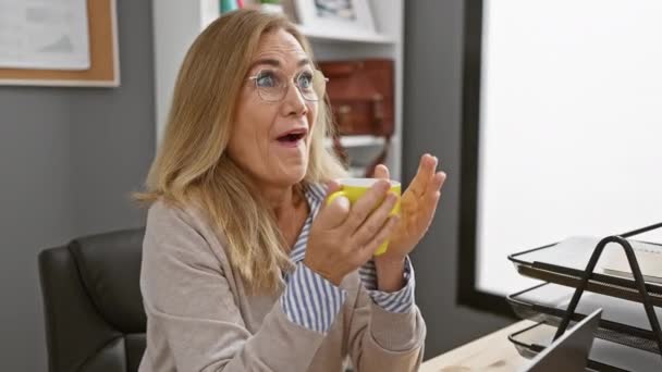 Ενθουσιασμένη Μεσήλικη Γυναίκα Γυαλιά Κρατώντας Κύπελλο Στο Γραφείο — Αρχείο Βίντεο
