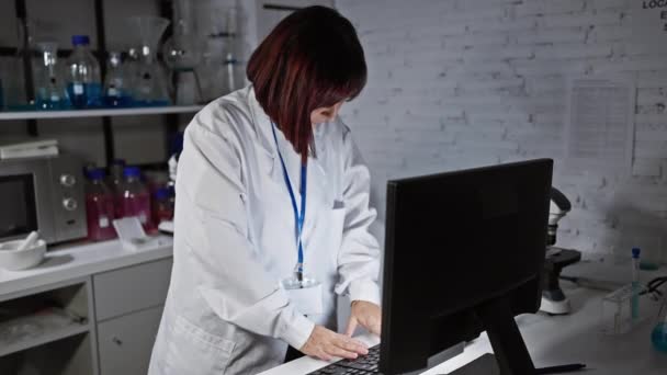 Μια Ώριμη Γυναίκα Επιστήμονας Μια Ρόμπα Εργαστηρίου Χρησιμοποιεί Έναν Υπολογιστή — Αρχείο Βίντεο