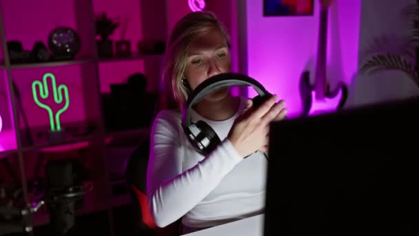 白种人女人晚上在霓虹灯下的游戏室里用耳机 — 图库视频影像