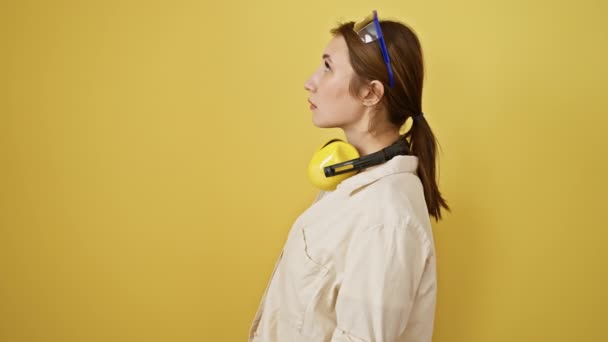 Selbstbewusste Junge Brünette Frau Schutzbrille Und Lärmreduzierende Kopfhörer Aufsetzend Strahlt — Stockvideo