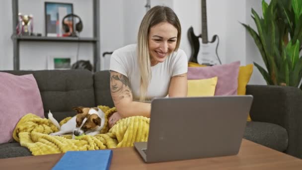 Uma Jovem Trabalha Laptop Casa Com Cachorro Jack Russell Brincando — Vídeo de Stock