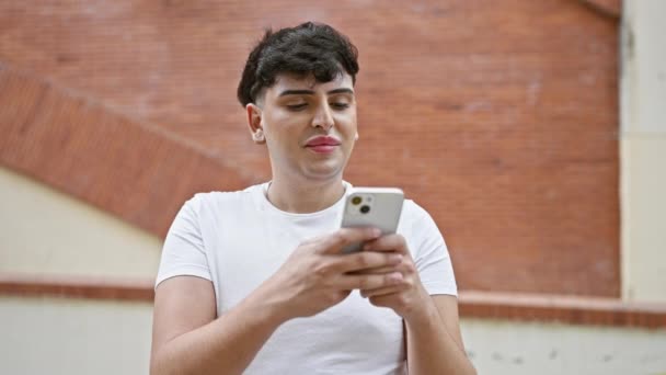 Şehirde Akıllı Telefon Kullanırken Gülümseyen Saçları Olan Genç Bir Adam — Stok video