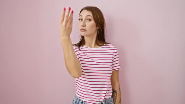 ストライプTシャツの陽気な若いブルネットガールは スタークピンクの孤立した背景の上にイタリアの手のジェスチャーを実行自信を持って — ストック動画
