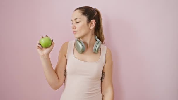 Молода Іспаномовна Жінка Блакитними Очима Спортивному Одязі Навушниках Тримає Яблуко — стокове відео