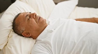 Parlak ve rahat bir yatak odasında huzur içinde uyuyan olgun İspanyol bir adam..