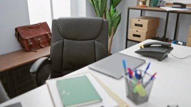Ofis masasında dizüstü bilgisayarı ve ofis malzemeleriyle çalışan profesyonel bir İspanyol..