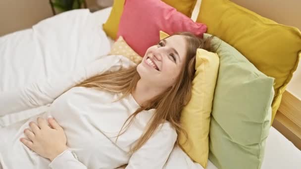 Neşeli Genç Sarışın Kadın Neşe Içinde Pijama Giyerek Yatakta Otururken — Stok video