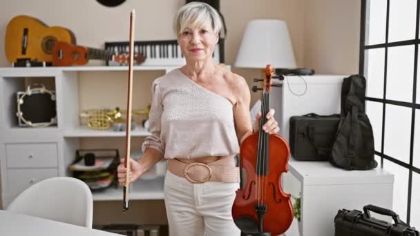 Elegant Mature Woman Holding Violin Bow Music Studio Instruments Background — Stock Video