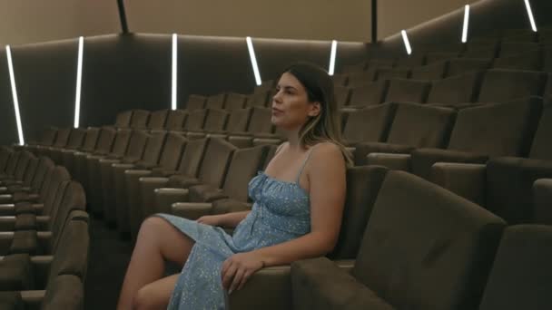 Uma Jovem Contemplativa Senta Sozinha Cinema Com Iluminação Ambiente Exalando — Vídeo de Stock