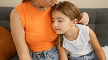 Bir annenin, sıcak bir oturma odasında kızına sarılıp aile sevgisini ve sevgisini sergilediği hassas bir an..