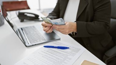 Olgun bir İspanyol kadın ofis masasında Şili pezosu sayıyor, finansal bir mesleği ima ediyor..