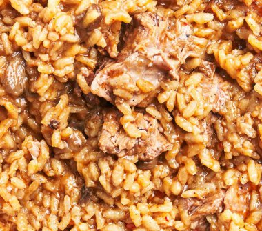 Pirinç dokusunu ve et parçalarını vurgulayan geleneksel sığır pilavının yakın plan görüntüsü