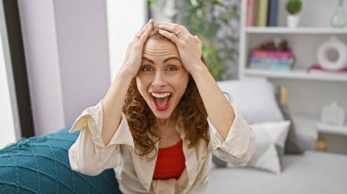 Neşeli genç bir kadın, kendine güveni tam, evinde rahat bir kanepede otururken bir sürprizle yakalanıyor.