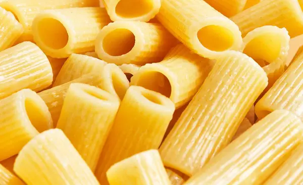 Close View Uncooked Italian Penne Pasta Textured Surface Vibrant Yellow — Stock Photo, Image