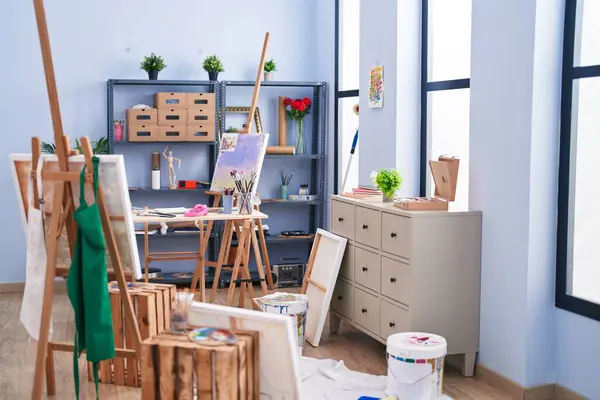Easels, paintings, and art supplies create an inspiring artist\'s studio with abundant natural light.