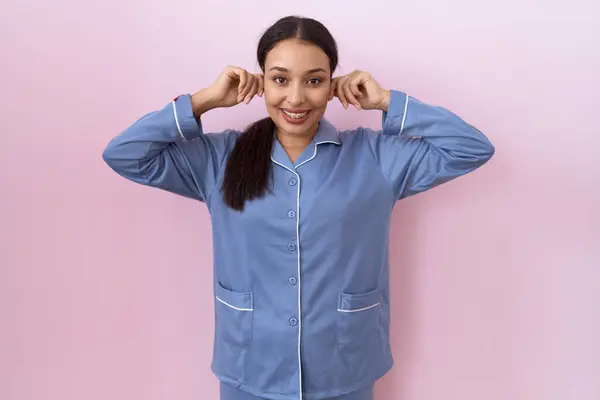 青いパジャマを着た若いアラブの女性は 指で耳を引っ張る笑顔 面白いジェスチャー オーディション問題 — ストック写真