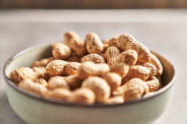 Seramik kasedeki kabuksuz fıstıklardan oluşan yakın çekim, sağlıklı doğal bir atıştırmalık sergiliyor..