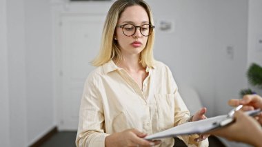 Genç sarışın iş kadını ofiste kontrat imzalıyor.