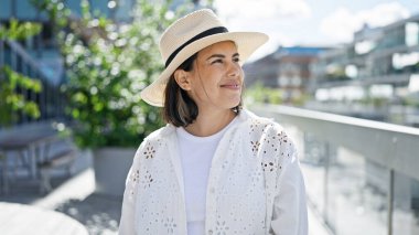 Stockholm sokaklarında yaz şapkası takmış kendine güvenen güzel İspanyol bir kadın.