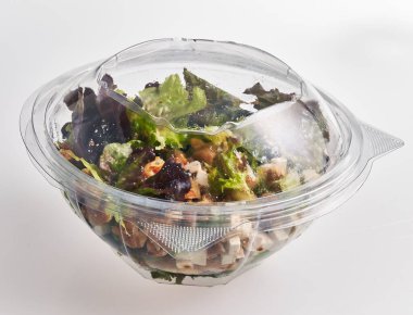 Mühürlü plastik bir kasede sağlıklı beslenme gösteren hazır taze bir salata..