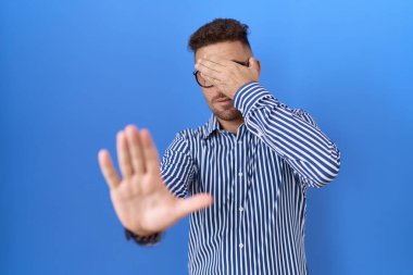 Sakallı, gözlüklü, elleri gözlüklü, üzgün ve korku dolu hareketler yapan İspanyol bir adam. utangaç ve olumsuz kavram. 