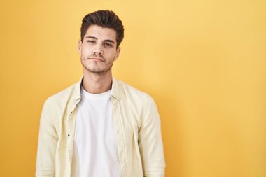 Sarı arka planda duran İspanyol genç adam uykulu ve yorgun görünüyor, yorgunluktan bitkin ve akşamdan kalma, sabahları tembel gözler.. 