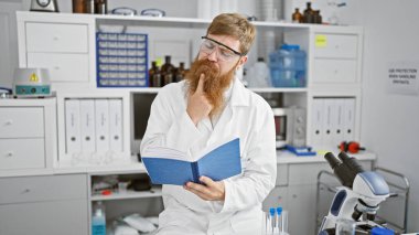 Yakışıklı genç kızıl saçlı, ciddi bir bilim adamı araştırma kitabı okumaya dalmış, titreyen bir laboratuvarın kalbinde derin düşüncelere dalmış..