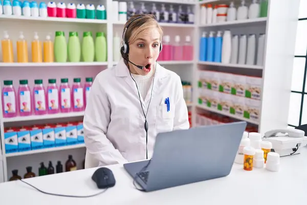 Young Caucasian Woman Working Pharmacy Drugstore Using Laptop Scared Amazed — Stock Photo, Image