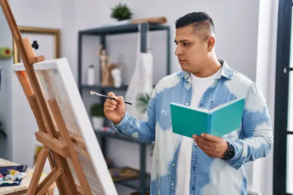 Young Latin Man Artist Reading Book Drawing Art Studio — Photo