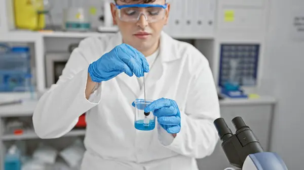 A scientist mixes chemicals in a lab, capturing the precision of scientific research.