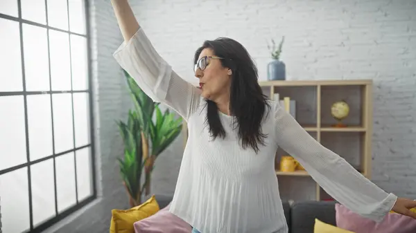 Spaanse Vrouw Stretching Binnen Met Een Lichte Moderne Woonkamer Achtergrond — Stockfoto